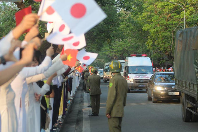 Quốc kỳ của 2 nước Việt Nam và Nhật Bản được các bạn sinh viên, học sinh cầm trên tay chào đón Nhật hoàng và Hoàng hậu.
