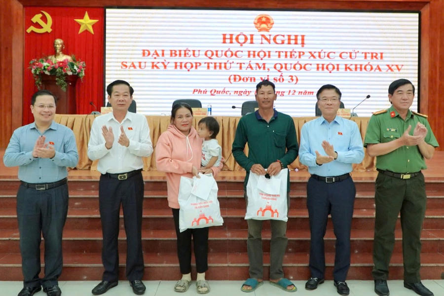 Phó Thủ tướng Chính phủ Lê Thành Long (đứng thứ 2 từ phải qua) và Bí thư Tỉnh ủy Đỗ Thanh Bình (thứ 5 từ phải qua) cùng các đại biểu Quốc hội tặng quà cho hộ dân nghèo trên địa bàn TP Phú Quốc - Ảnh: Khánh Thùy