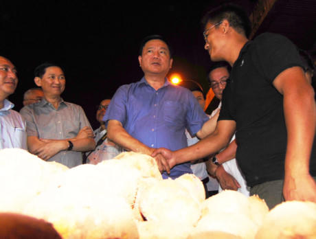 Bí thư Thành ủy TP.HCM trò chuyện thân mật với anh Nguyễn Đình Bảo (bìa phải) kinh doanh khoai tây ở chợ đầu mối Hóc Môn. Ảnh: LÂM NGỌC