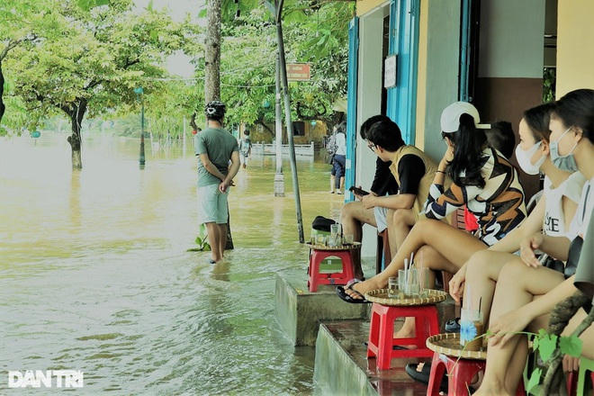 Người dân địa phương thích thú với cảnh nước lũ đầu mùa nên thường chọn những quán cà phê vỉa hè với