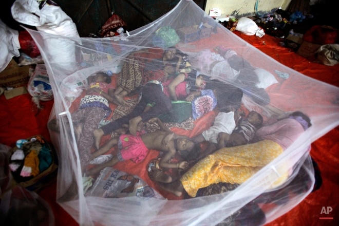 Phụ nữ và trẻ em người dân tộc Rohingya nằm ngủ tại một trại tạm trú ở Langsa, tỉnh Aceh, Indonesia ngày 17/5. Các di dân nói không thể trở về Myanmar, bởi họ không được thừa nhận là công dân nước này và thường bị ngược đãi.  Ảnh: AP.