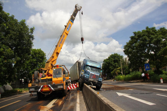 Lực lượng chức năng dùng cần cẩu để 'giải cứu' chiếc xe container.