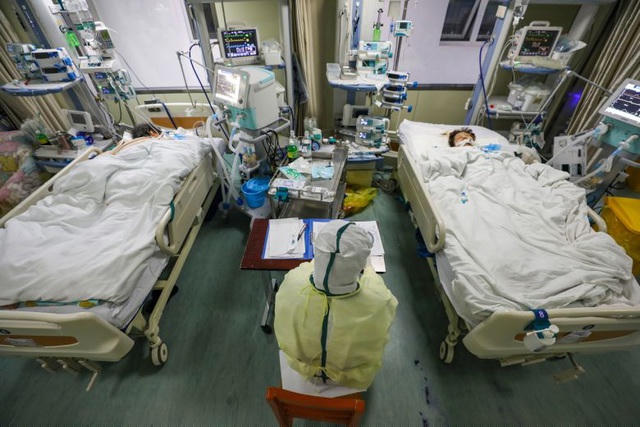 Một nhân viên y tế theo dõi các bệnh nhân tại phòng chăm sóc đặc biệt ở Vũ Hán hôm 6/2. (Ảnh: EPA)