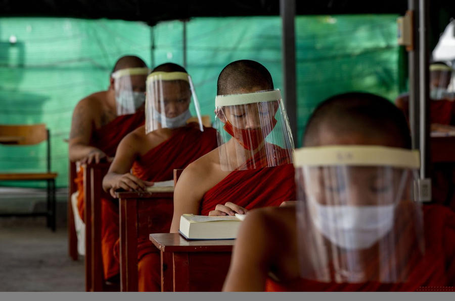 Những chú tiểu tại Thái Lan đeo khẩu trang và mặt nạ nhựa phòng sự lây lan của virus. (Nguồn: AP)