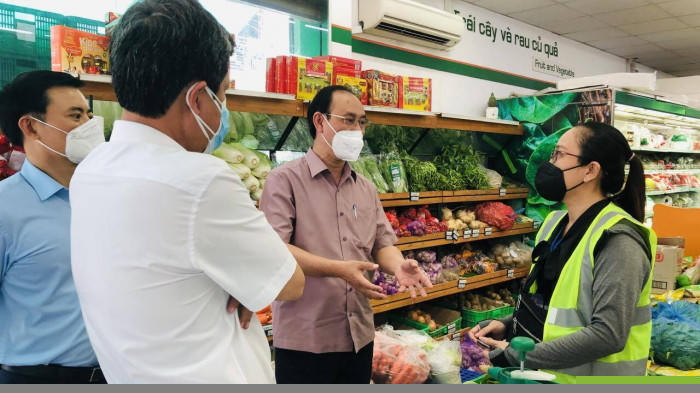 Thứ trưởng Lê Đình Thọ (giữa) vào siêu thị kiểm tra nơi phân phối hàng hóa cho người dân ở quận Tân Phú (TP.HCM).