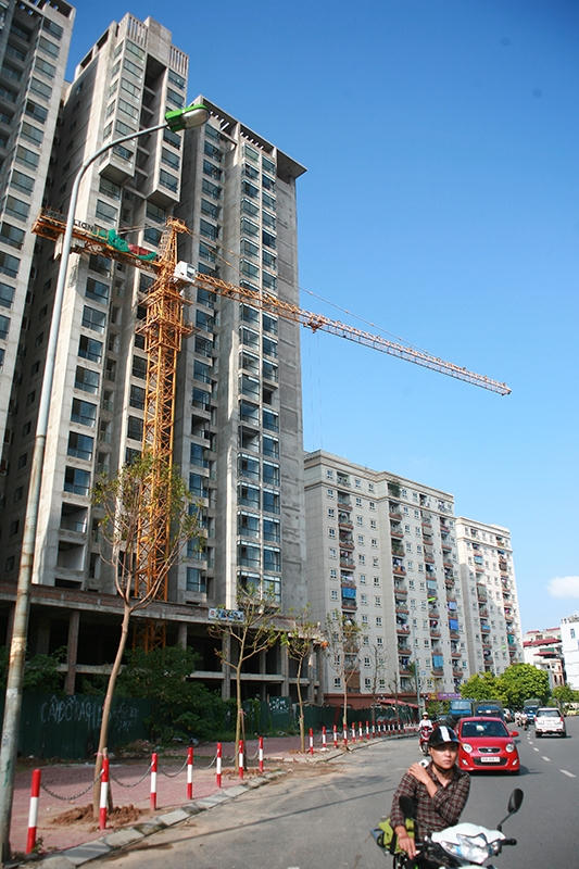 Trong ảnh là cẩu tháp trên phố Vũ Phạm Hàm thò hẳn ra bên ngoài đường khi dòng người vẫn đang di chuyển bên dưới