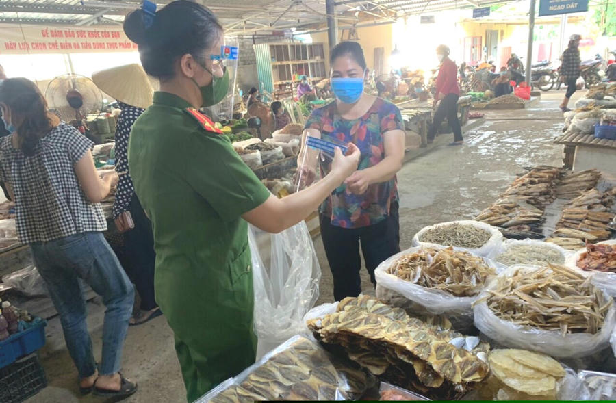 ông an thị trấn Hậu Lộc tuyên truyền quy định về phòng, chống dịch và tặng kính chắn giọt bắn cho Nhân dân trên địa bàn