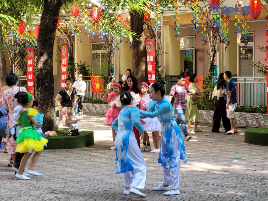 Các bạn bạn học sinh nô đùa nhau nhân ngày khai giảng năm học mới tại sân trường.