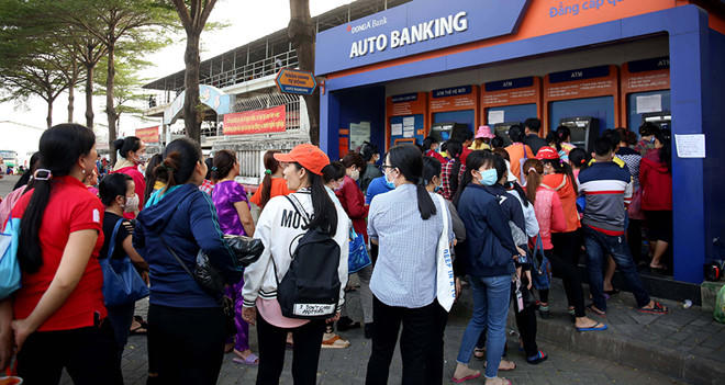 Công nhân xếp hàng chờ rút tiền từ máy ATM chiều 28.1
