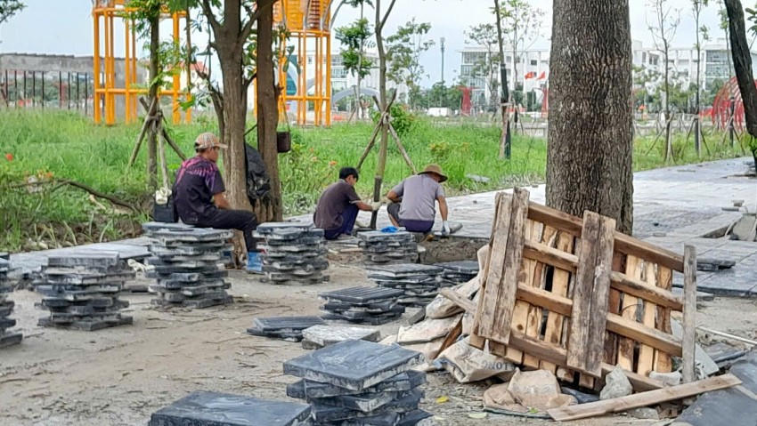 Công nhân đang lát đá trong khuôn viên công viên.