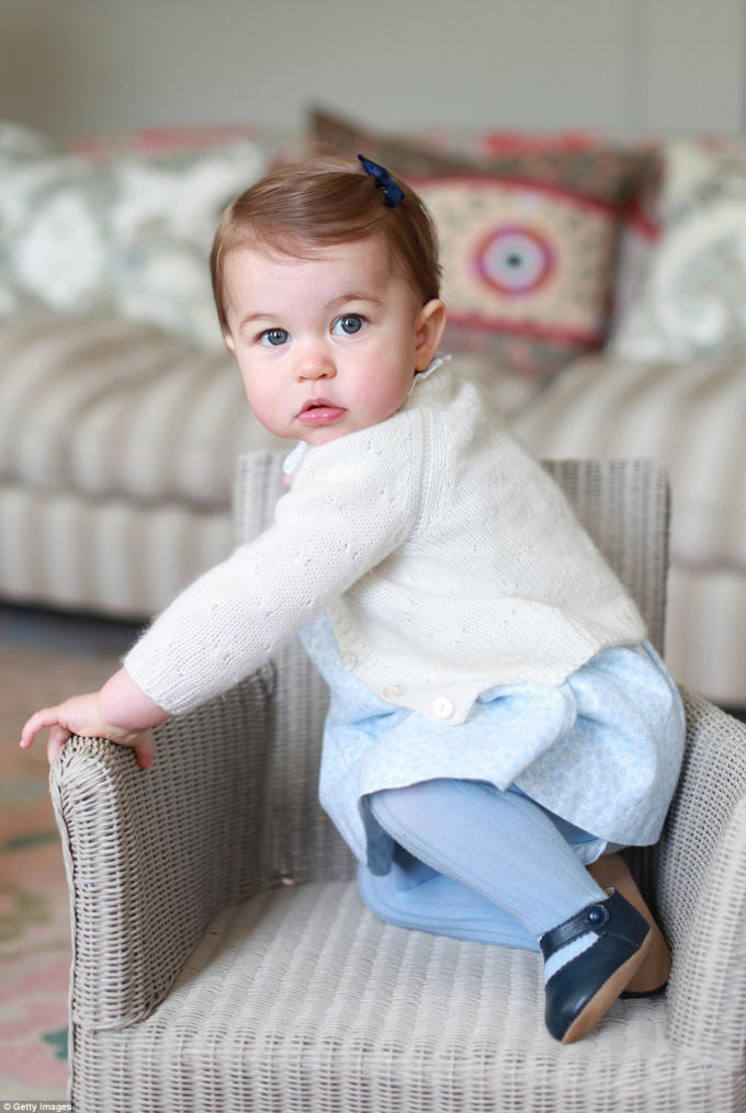 Công chúa Charlotte ngồi lên một chiếc ghế nhỏ, mắt tròn xoe nhìn mẹ Kate.