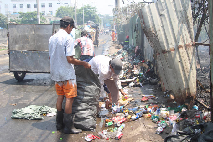 C&ocirc;ng nh&acirc;n thu gom r&aacute;c sau vụ ch&aacute;y.