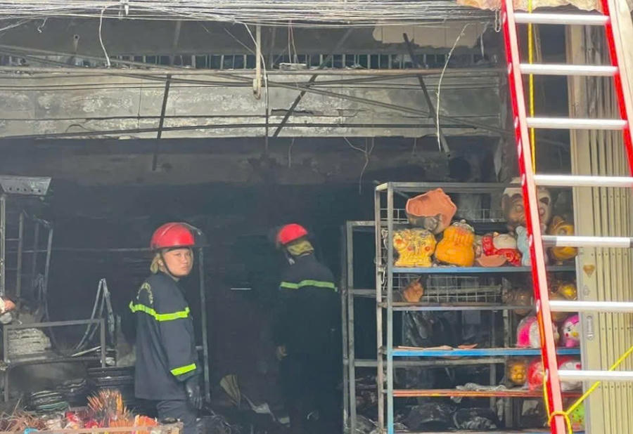 Lực lượng chức năng đưa nạn nhân ra khỏi hiện trường vụ cháy. Ảnh: Xuân Ngọc