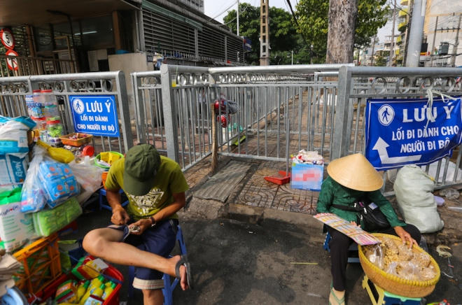 Ở cổng chính bệnh viện, tình trạng hàng rong còn bát nháo hơn. Những người bán hàng bày biện đủ hàng hóa, bàn ghế và ngồi chắn ngay cả lối vào vỉa hè.