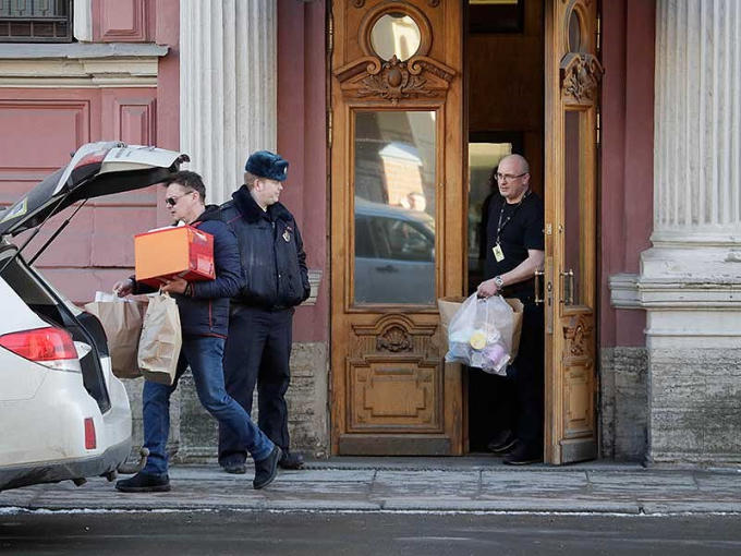 Nhân viên lãnh sự quán Mỹ tại St. Petersburg thu dọn hành lý ra khỏi trụ sở ngày 30-3, sau khi Nga ra lệnh đóng cửa lãnh sự. Ảnh: AP