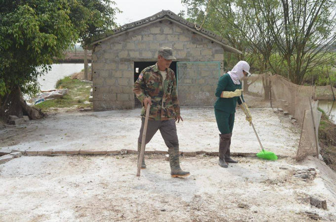 Gia đình là nhà ông Nguyễn Văn Bẩy, xã Trực Thuận (Trực Ninh, Nam Định) phun thuốc, rắc vôi bột khử trùng quanh nhà.