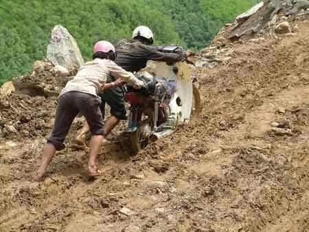 Đường tới trường ngập bùn không thể đi xe máy được mà phải vừa dắt vừa đẩy.