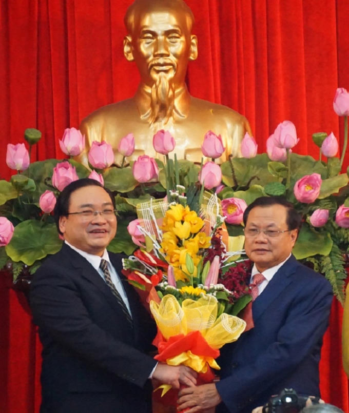 Ông Hoàng Trung Hải nhận bó hoa chúc mừng từ ông Phạm Quang Nghị.