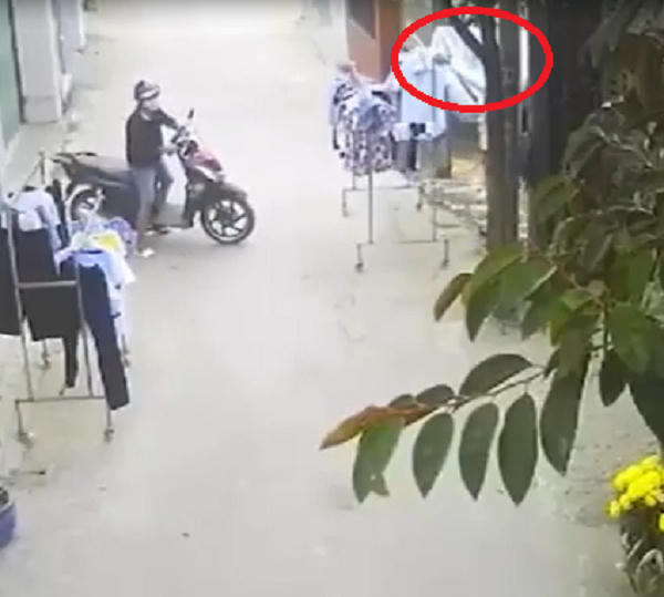 Thanh niên nhanh tay cuỗm quần áo đang phơi trên sào. (Ảnh: Cắt từ clip).