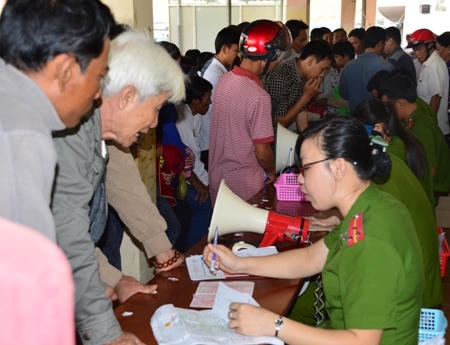 Cán bộ công an hướng dẫn người dân làm thủ tục.