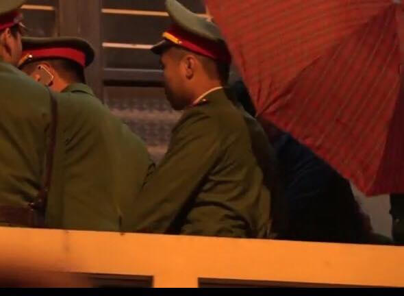 Ông Đinh La Thăng được che chắn ô để đưa ra xe.