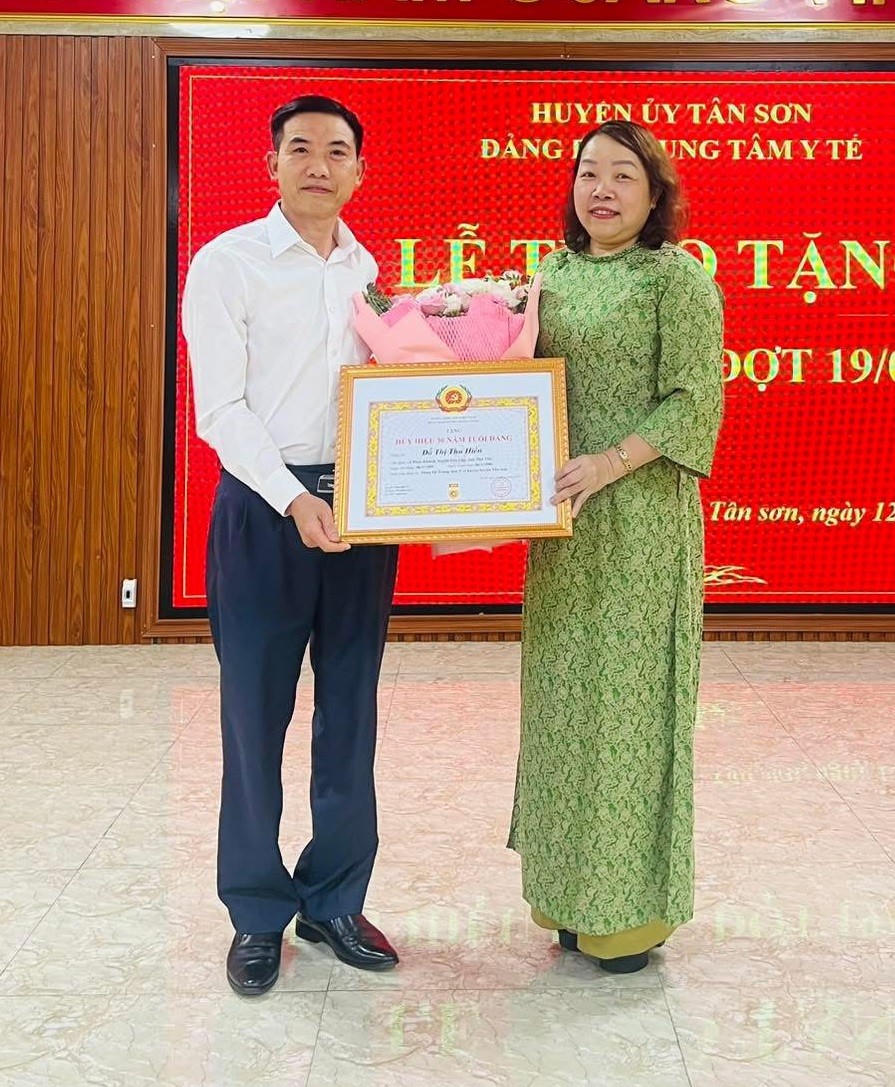 Ông Trần Khắc Thăng trao Huy hiệu 30 năm tuổi Đảng cho Phó Bí thư Đảng ủy, Phó Giám đốc Trung tâm Y tế huyện Tân Sơn.