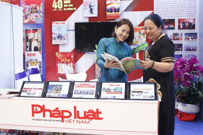 Phóng viên Báo Pháp luật Việt Nam giới thiệu ấn phẩm cho độc giả tại gian trưng bày.