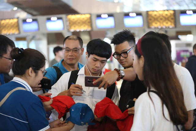 Người hâm mộ tranh thủ chụp ảnh cùng Công Phượng ở sân bay