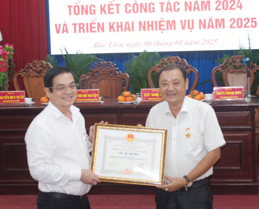 Ông Huỳnh Chí Nguyện (bên trái) - Phó Chủ tịch UBND tỉnh Bạc Liêu trao tặng Danh hiệu chiến sĩ thi đua của Chủ tịch UBND tỉnh cho ông Vưu Nghị Bình - Giám đốc Sở Tư pháp Bạc Liêu.