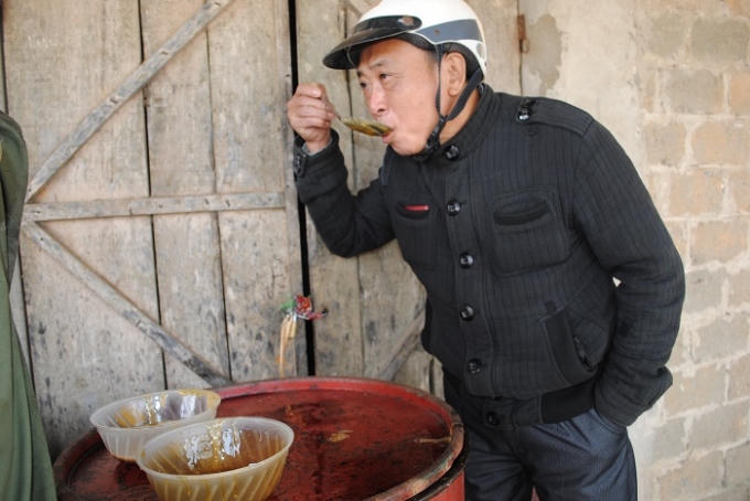 Một lái buôn nếp thử mật mía trước khi mua (ảnh Duy Ngợi).