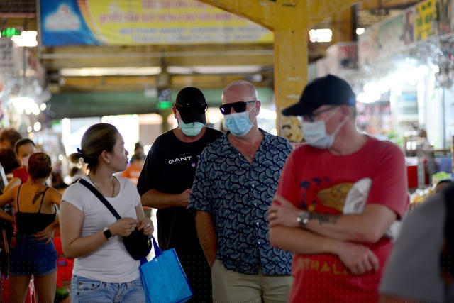 Khách nước ngoài đã phòng dịch bằng cách bịt khẩu trang khi tham quan chợ.