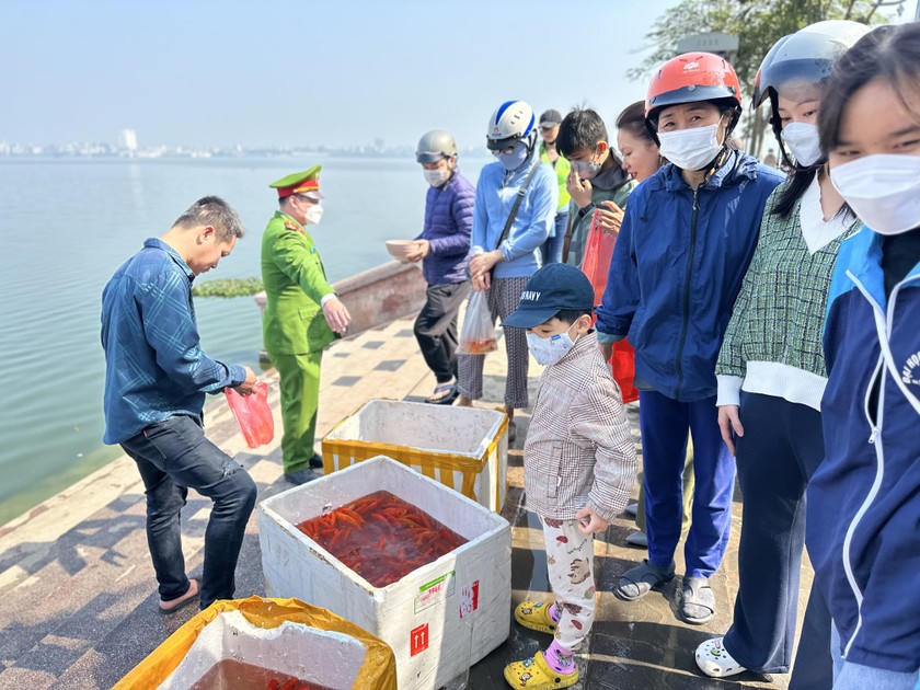 Lực lượng chức năng hướng dẫn người dân thả cá vào thùng xốp.