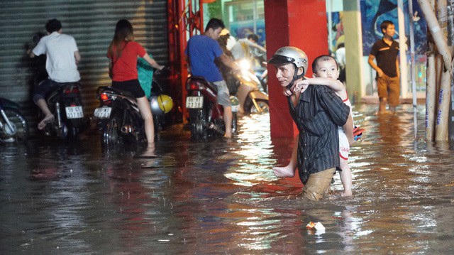 Người dân lội nước trên đường Phan Huy Ích (ảnh: Trương Nhân)