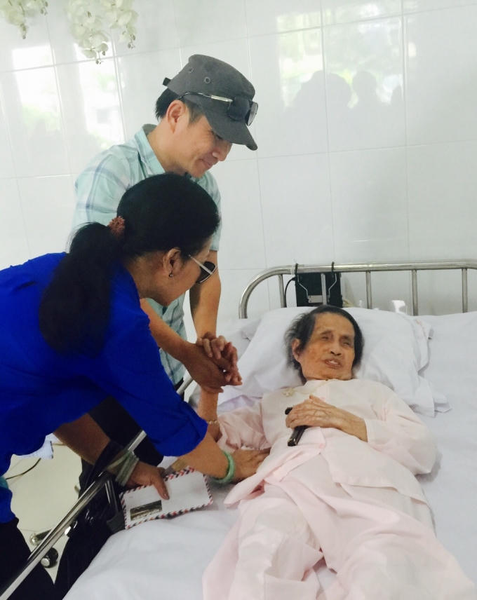 Ca sĩ Khánh Ly và ca sĩ Quang Thành đang cúi xuống thật gần để chia sẻ với những phận đời khốn khó