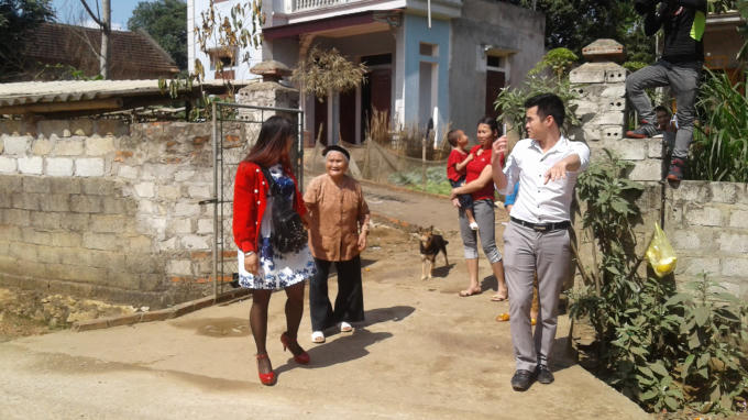 Chị Hà (mặc váy) bùi ngùi cố gắng nhớ lại những người hàng xóm cạnh nhà. Ảnh: Nguyệt Chi