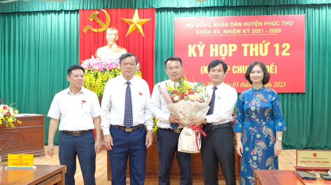 Ông Nguyễn Đình Sơn nhận hoa chúc mừng từ lãnh đạo Huyện uỷ Phúc Thọ. Ảnh: Tiền Phong