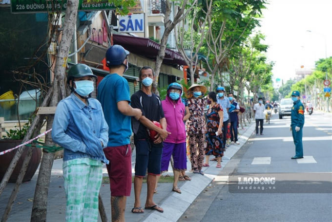 Nhiều người dân xếp hàng chờ đợi tại đường số 48 (Quận 4) để chờ tới lượt mua sắm.