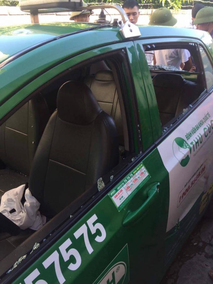 Chiếc taxi bị ném vỡ kính hông (Ảnh: facebook)