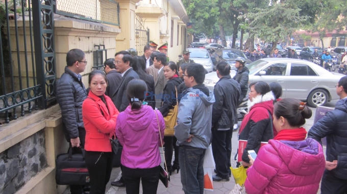 Nhiều người đang làm thủ tục để vào tham dự phiên tòa xét xử vụ án.