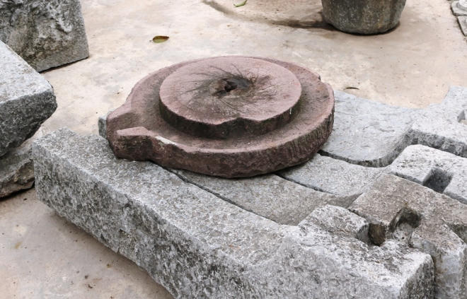 Chiếc cối xay bột bằng đá mài được sư Thắng cho biết có niên đại cả trăm năm tuổi.