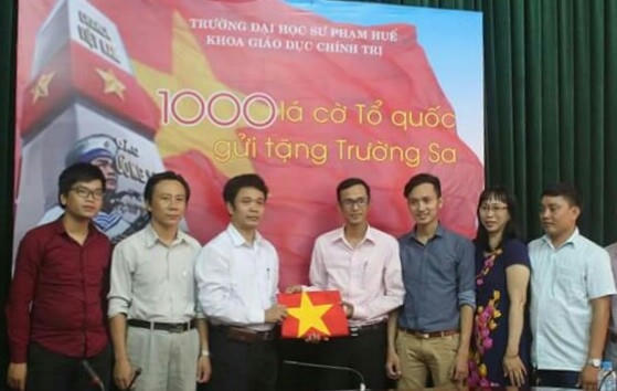 PV Đăng Hậu - Pháp luật Plus (bên phải) đại diện nhóm trao tặng 130 lá cờ Tổ quốc cho chương trình "1.000 lá cờ Tổ quốc cho Trường Sa" do khoa Giáo dục Chính trị, Trường ĐH Sư phạm Huế phát động.