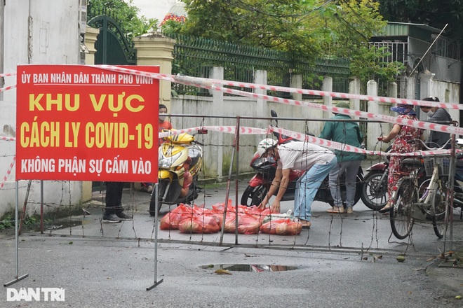 Người dân trong khu vực cách ly chống Covid-19 tại TP Vinh, Nghệ An nhận tiếp phẩm (Ảnh: Hoàng Lam).