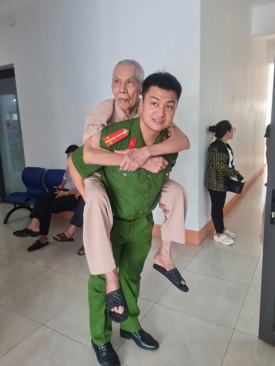 Hình ảnh đồng chí Công an trẻ cõng vị đảng viên lão thành đi làm thủ tục đổi Thẻ đảng viên được cộng đồng mạng yêu thích.