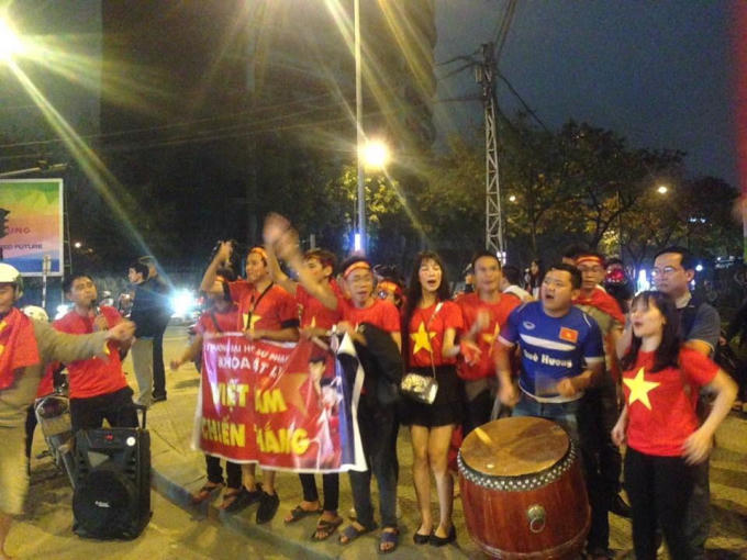 Một nhóm cổ động viên đưng ven đường đánh trống thổi kèm mừng chiến thắng...