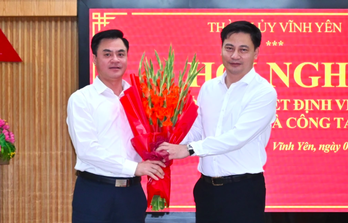 Bí thư Thành ủy Vĩnh Yên Nguyễn Trung Hải (phải) tặng hoa chúc mừng ông Đào Văn Quyết, Quyền Chủ tịch UBND thành phố Vĩnh Yên.