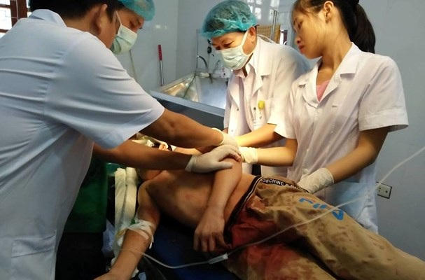 Y, bác sỹ Trung tâm y tế huyện Tân Kỳ phẫu thuật, khâu vết thương cứu bệnh nhân. (Ảnh: Báo Nghệ An)