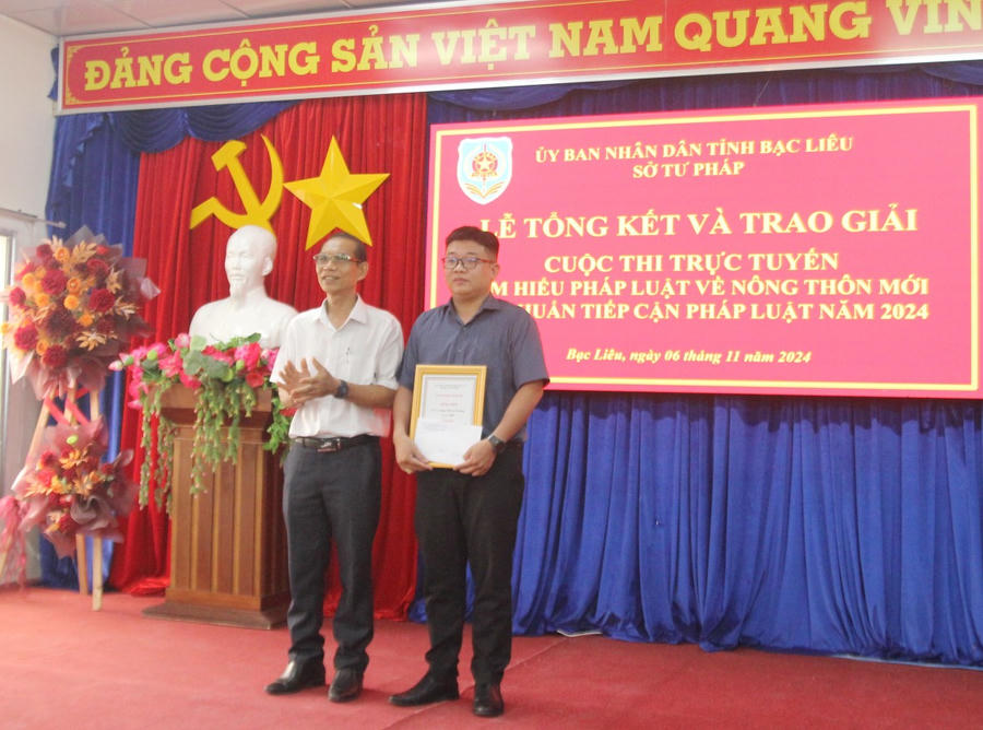 Ông Trần Minh Đức - Phó Giám đốc Sở Tư pháp Bạc Liêu, Phó Trưởng Ban Tổ chức Cuộc thi, trao giải Nhì cho tập thể Trường THPT Lê Thị Riêng (huyện Hòa Bình, tỉnh Bạc Liêu).