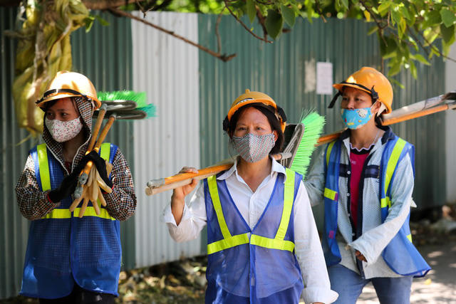 Nh&oacute;m c&ocirc;ng nh&acirc;n đi l&agrave;m về giữa trưa.