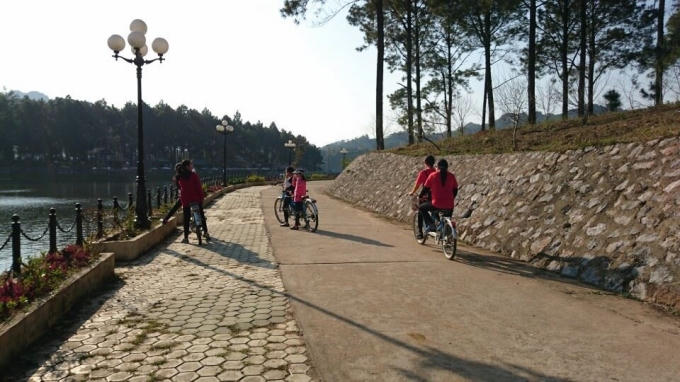 Các bạn trẻ đạp xe đạp ở đường ven hồ.(ảnh: Minh Long).