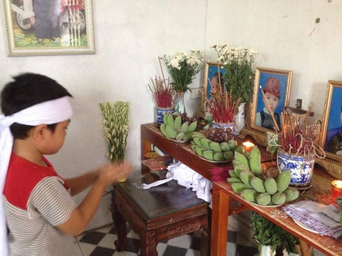 Cháu Trần Văn Khánh bên bàn thờ,  khiến ai chứng kiến không  khỏi xót xa.